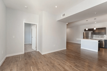 A living room and kitchen with a hard wood floor